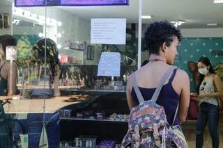 Cliente sem máscara espera para entrar em loja de maquiagem em Campo Grande (Foto: Kisie Ainoã)