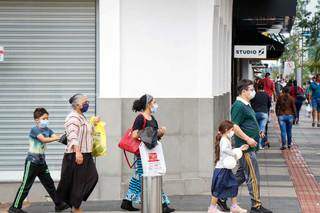 Crianças e adultos usam máscara para andar nas ruas da Capital (Foto: Henrique Kawaminami)