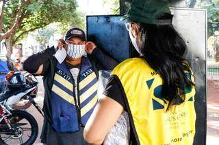 Rudnei coloca máscara doada por voluntária (Foto: Henrique Kawaminami)