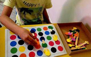Criança brincando com as peças do jogo de estimulação visual. (Foto: Arquivo pessoal)