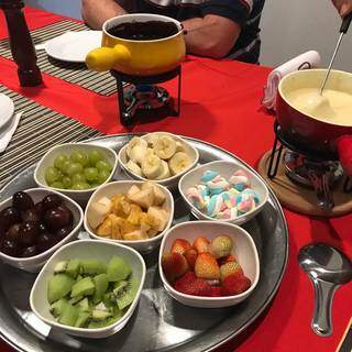 Fondue de queijo na panela à esquerda e de chocolate na direita, de acompanhamento tem as frutas; morango, kiwi, uva, banana, além do marshmallow. (Foto: Arquivo pessoal)