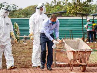 Funcionários de cemitério fazem desinfecção de materiais em enterro no início de junho. (Foto: Arquico/ Campo Grande News)