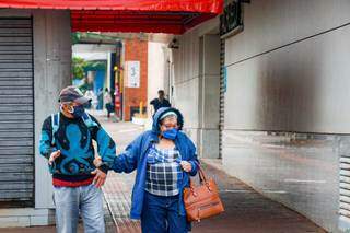 Casal usando máscara de proteção no Centro de Campo Grande: essa ainda é uma das maiores recomendações para evitar a doença. (Foto: Henrique Kawaminami)