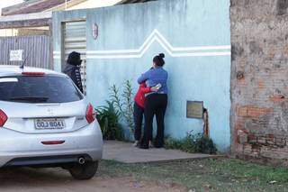 Camila (de vermelho), irmã da vítima, é consolada na frente da casa onde a família mora, no Tiradentes. (Foto: Kísie Ainoã)
