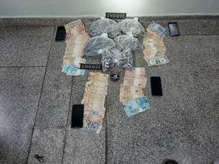 Dinheiro, celulares e cápsulas de cocaína apreendidos com os criminosos. (Foto: Choque)