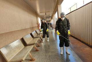 Soldado do Exército faz desinfecção em corredor do HU, em Dourados (Foto: Divulgação)