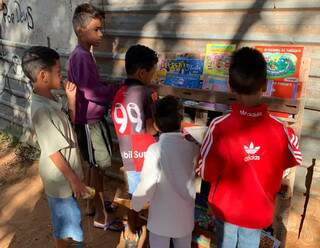 Meninos escolhem livros que foram doados em campanha (Foto: Divulgação)