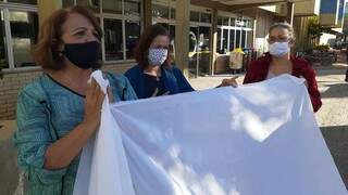 Shirley, Helena e a médica Cenilse com bandeiras brancas em frente ao Hospital Evangélico (Foto: Divulgação)