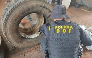 Policial retira pacotes de agrotóxico dos pneus de carreta (Foto: Divulgação)