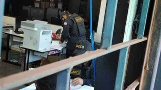 Policiais do Gaeco vasculham documentos em sala da Secretaria de Fazenda, ontem, em Dourados (Foto: Adilson Domingos)
