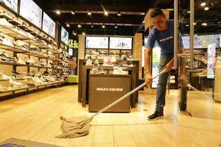 Funcionário limpa loja, em 22 de abril, quando shoppings reabriram em Campo Grande. (Foto: Arquivo)