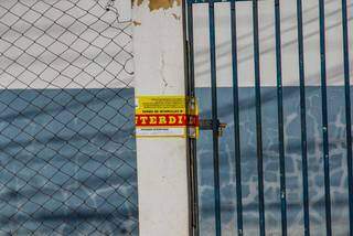 Lacre de interdição no portão da quadra de futebol, situada no Bairro São Francisco (Foto: Silas Lima)