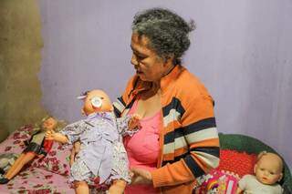 Nas mãos da mãe, boneca que a jovem assassinada havia mandado reformar há dois meses. (Foto: Silas Lima)