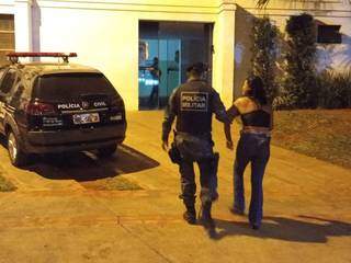 Mulher sendo levada por policial militar (Foto: Reprodução/Jornal da Nova)