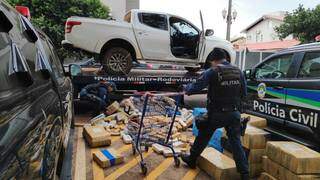 Policiais descarregam droga de Triton apreendida na madrugada (Foto: Adilson Domingos)