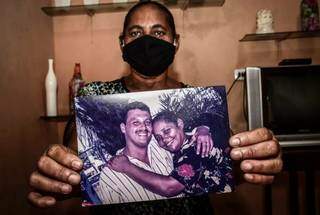 Esposa segura foto de Alexandre; depoimento da esposa do preso emocionou o advogado de Campo Grande (Foto: Veetmano/Agência JC Mazella)