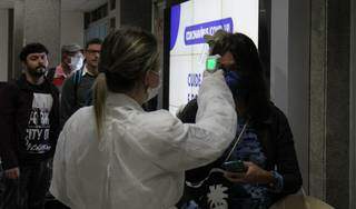 Passageira passa por aferição de temperatura no aeroporto da Capital (Foto: Chico Ribeiro/Segov)