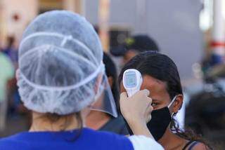 Profissional da Vigilância Sanitária afere temperatura em Campo Grande, (Foto: Marcos Maluf)