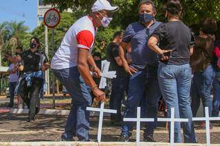 Manifestante coloca cruzes no Centro de Campo Grande, em protesto contra mortes por covid no País. (Foto: Marcos Maluf)