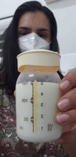Luciana mostrando o leite que conseguiu retirar do peito e armazenar num recipiente para o filho. (Arquivo pessoal)