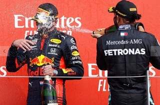 Hamilton joga champanhe no rosto do holandês, após vitória em Silverstone.&nbsp;(Foto: Andrew Boyers/AFP)