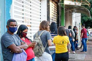 Dia começa sempre fila com em frente à Funtrab, no Centro de Campo Grande. (Foto: Henrique Kawaminami)