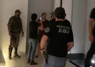 Abordagem policial na casa do empresário, no Damha 3; no fundo, de bermuda, Aloisyo Coutinho conversa com policiais antes de ser preso (Foto: Direto das Ruas)