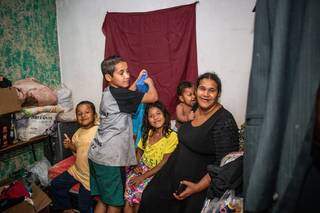 Cristiane com quatro, dos cinco filhos, no único quarto da casa. (Foto: Henrique Kawaminami)