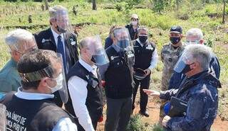 André Mendonça (de camisa branca, ao centro) conversa com militar paraguaio em área de cultivo de maconha na fronteira (Foto: Senad/Divulgação)