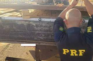 Policial rodoviário federal abrindo carroceria de caminhão onde estava escondida mais de meia tonelada de maconha (Foto: Divulgação/PRF)