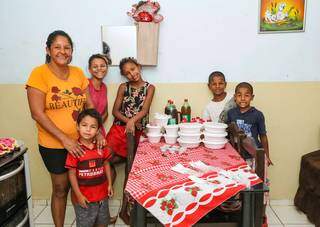 Dona Eliana e suas crianças posam diante da mesa pronta para o almoço de sobá. (Foto: Kísie Ainoã)