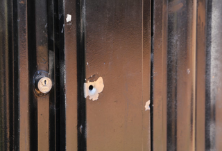 Marcas de tiros no portão da casa da vítima, no Jardim Itamaracá (Foto: Kisie Aionã) 