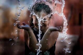 Menina ameniza calor bricando com água (Foto: Marcos Maluf)