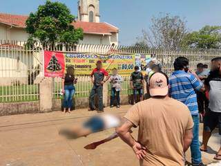 Moradores em volta do corpo de homem executado em Ponta Porã; cena corriqueira (Foto: Ademir Almeida)