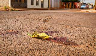 Marcas de sangue no asfalto no local onde homem foi morto. (Foto: Henrique Kawaminami)