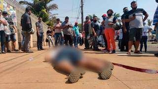 Moradores obervam corpo em calçada de igreja em Ponta Porã (Foto: Ademir Almeida)