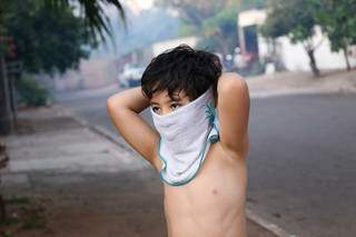 Por causa de fumaça, menino usa toalha molhada no rosto (Foto: Paulo Francis)