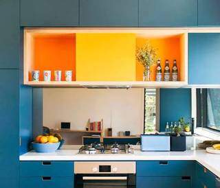 A pintura em tons de amarelo e laranja combinou perfeitamente com os armários em acabamento azulado (Foto: Reprodução/Pinterest)