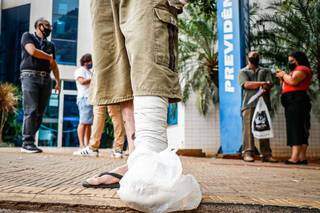 Homem, com o pé quebrado, aguarda por atendimento em agência de Campo Grande (Foto: Henrique Kawaminami)