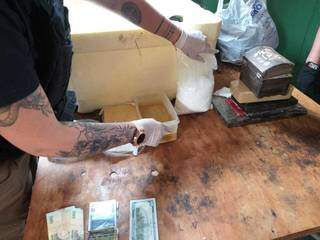 Agente da Senad separa pacotes de cocaína em laboratório (Foto: Divulgação/Senad)