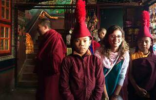 Ju ao lado de meninos vestidos com roupa tradicional nepalense (Foto: Arquivo Pessoal)