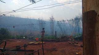 Com mangueira e baldes, moradores tentam controlar o fogo (Foto: Ana Paula Chuva)