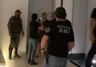 Abordagem policial na casa do empresário, no dia 15 de agosto; no fundo, de bermuda, Aloisyo Coutinho conversa com policiais antes de ser preso (Foto: Direto das Ruas)