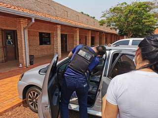 Agente da Senad paraguaia vistoria carro onde estava mulher de contador de organização criminosa. (Foto: Divulgação/Senad)