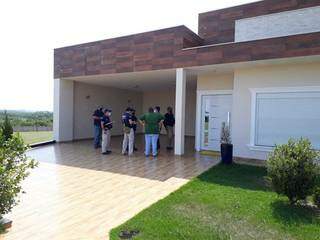 Policiais em frente à mansão onde chefe da máfia do cigarro foi preso (Foto: Divulgação)