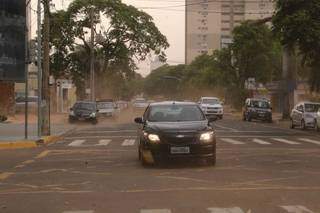 Carros em meio a nuvem de poeira no Centro de Campo Grande na tarde deste quarta-feira (14). (Foto: Kísie Ainoã)