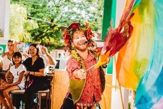 Criança sorri enquanto ator faz performance com tecidos coloridos (Foto: Arquivo Pessoal)