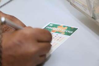 Números da sorte sendo marcados em lotérica de Campo Grande. (Foto: Kisie Ainoã) 
