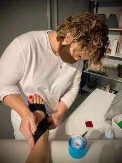 Fisioterapeuta Graziele prepara kinesio taping em tornozelo de paciente (Foto: Arquivo Pessoal)