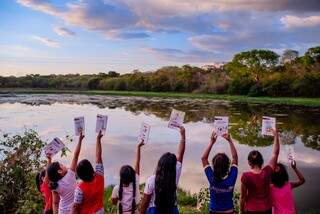 Crianças levantando os livros para o alto no Pantanal. (Foto: Luciano Justiniano)